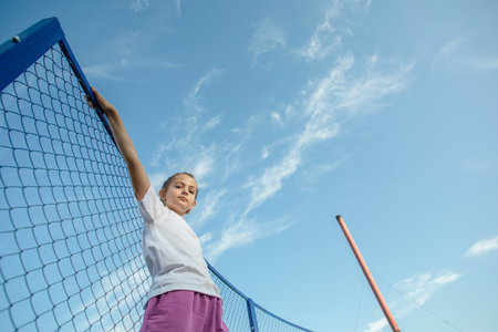Elevating Dreams: Courageous Girl Reaches for Her Goals Amidst the Endless Skylineの写真素材