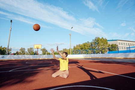 Passion and Poise: Student Girl Shines Bright on the Red Rubber Basketball Courtの写真素材