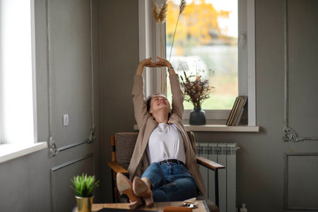 Smiling Young caucasian Female Manager Sitting On Chair Stretching Her Arms