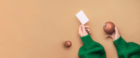 Christmas shopping concept. Flat lie hands in a green sweater with bonus card. Banner on a red backgroundの写真素材