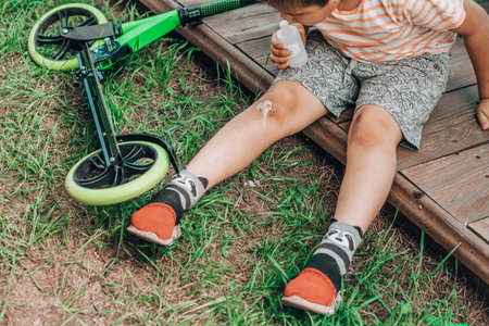 Brave Little Healer: A child focuses intently on applying a bandage to a scrape, a poignant first...