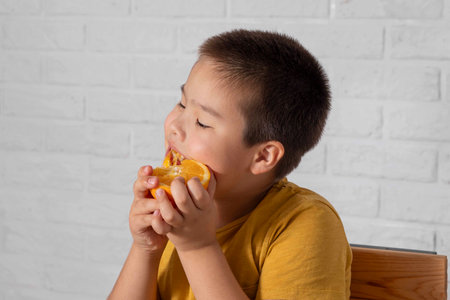 boy using oranges as playful goggles, bringing attention to the significance of Vitamin Cの写真素材