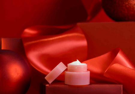 festive sophistication, ribbon and festive packaging, skin care, winter care moisturizer for Christmas on podiumの写真素材