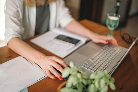 Comfort Meets Functionality in Home Office Setup, womens hands with a laptop at the table in workの写真素材