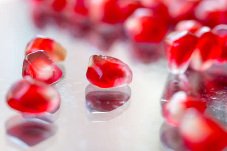 pomegranate seeds on glass plate and on white backgroundの写真素材
