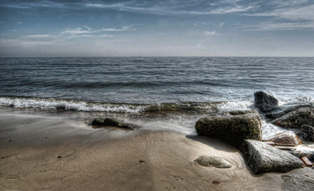 waves and rocks on a sandy beach hdr
