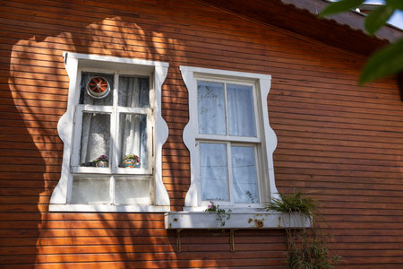 Vintage Wooden House with Windows and Shadowsの写真素材