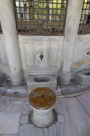 Close-Up View of Traditional Ottoman Ablution Fountain with Marble Basin and Stoolの写真素材