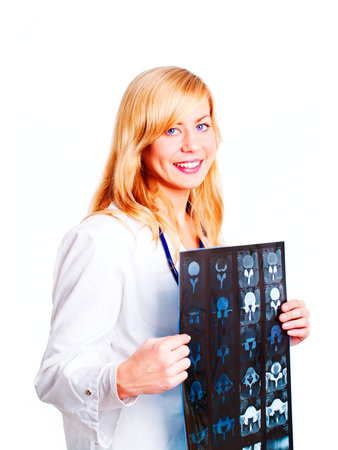 Portrait of female doctor examining x-ray picture over white backgroundの写真素材