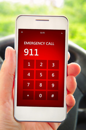 hand holding mobile phone with emergency number 911. focus on screenの写真素材