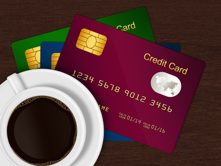 white cup of coffee with credit cards lying on wooden deskの写真素材