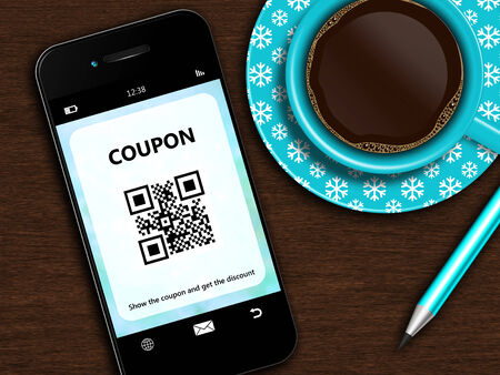 mobile phone with christmas coupon, cup of coffee and pencil lying on wooden deskの写真素材