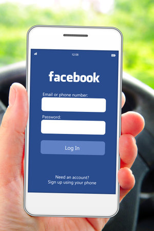 Gdansk, Poland - 3th of June 2014: hand holding mobile phone with facebook social network log in...