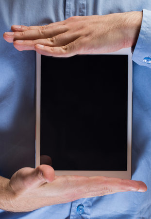 White tablet pc in hands over gray background