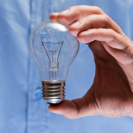 Close up of man hand with light bulb