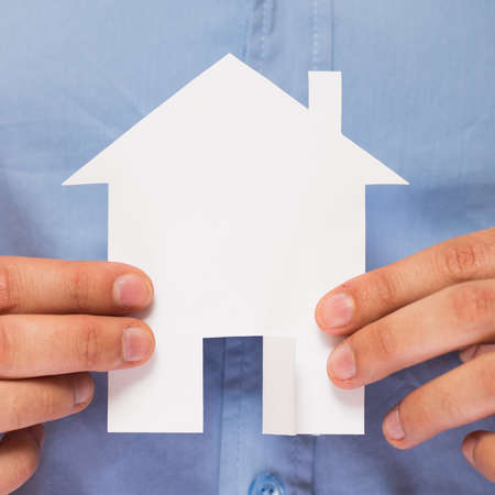 Close up of hands holding paper house in his handsの写真素材