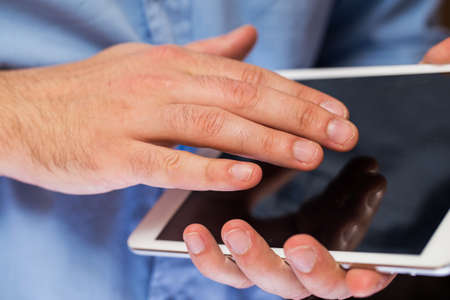 Close up of man hands holding white tablet pcの写真素材