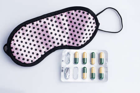 Mask and sleeping pills on the tableの写真素材