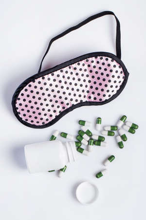 Mask and sleeping pills on white backgroundの写真素材