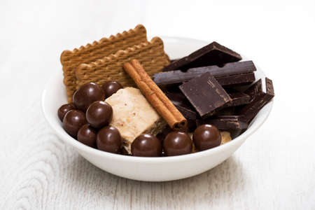 Bowl with  different sweets on bright tableの写真素材
