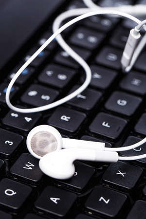 Earphones over laptop keyboardの写真素材