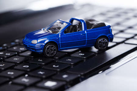 Toy car over laptop keyboardの写真素材