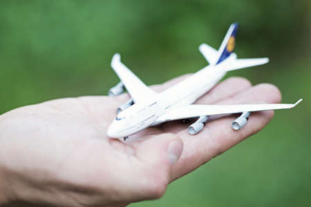 white toy airplane on palmの写真素材