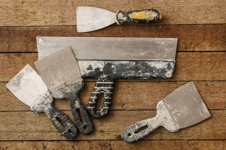 Kit of putty knives over wooden tableの写真素材