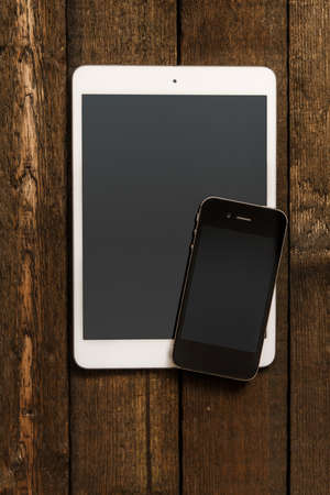 Smartphone and tablet over wooden surfaceの写真素材