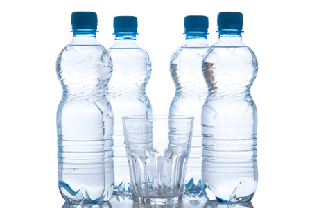 Glass and bottles with fresh water on white background