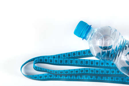 Bottle with water and measure tape on white backgroundの写真素材