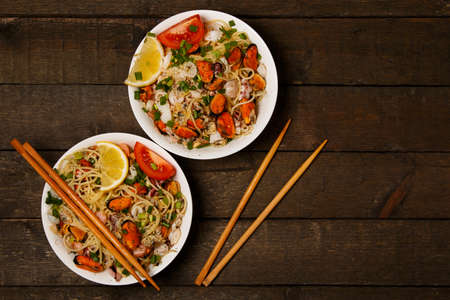 Noodles with seafood on wooden tableの写真素材