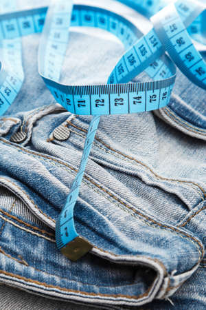 Close up of jeans and a measuring tapeの写真素材