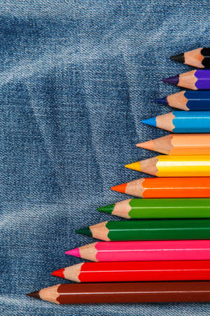 Multicolored pencils over jeans surfaceの写真素材