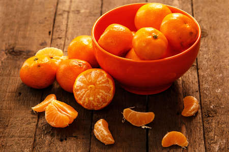 Fresh mandarins in bowl on wooden tableの写真素材