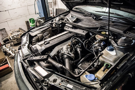 A car with an open hood in service