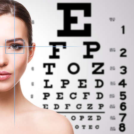 Beautiful woman and eye chart on backgroundの写真素材