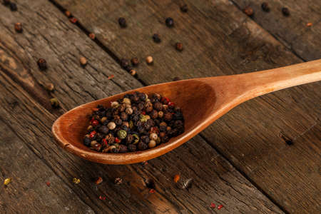 Wooden spoon and dried pepper seeds on white backgroundの写真素材