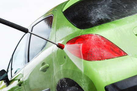 Green car in a hand car washの写真素材