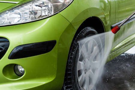 Green car in a hand car washの写真素材