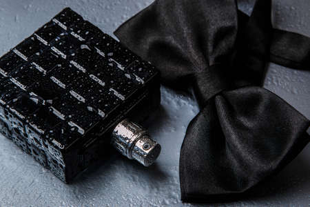 Bottle of male perfume and black bow tieの写真素材