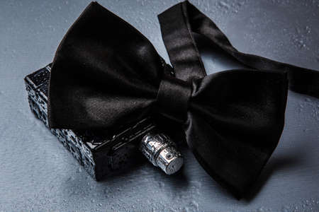 Bottle of male perfume and black bow tieの写真素材