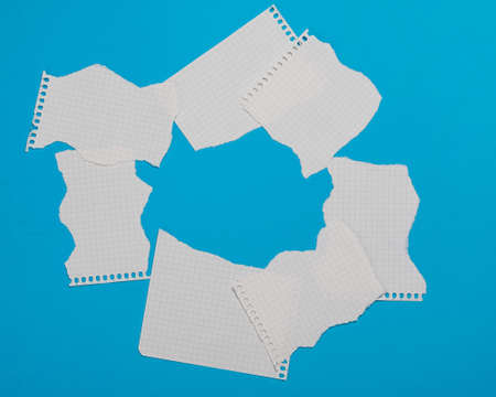 Torn pieces of checkered paper on blue backgroundの写真素材
