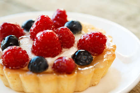 Delicious cake with berries on a kitchen tableの写真素材