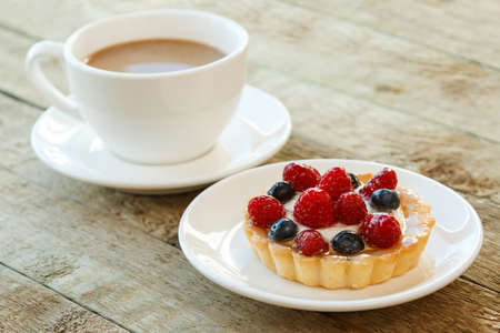 Delicious cake with berries and cup of coffeeの写真素材