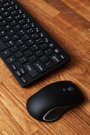 Keyboard and mouse on wooden tableの写真素材