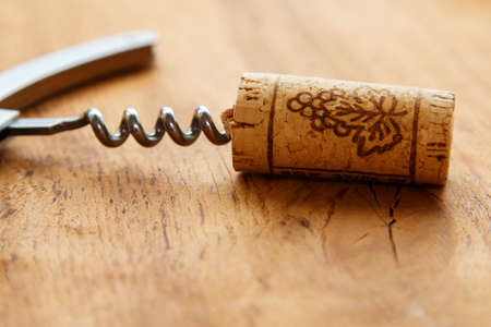 Corkscrew and corks on wooden tableの写真素材