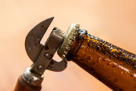 Vintage opener and beer over wooden surfaceの写真素材
