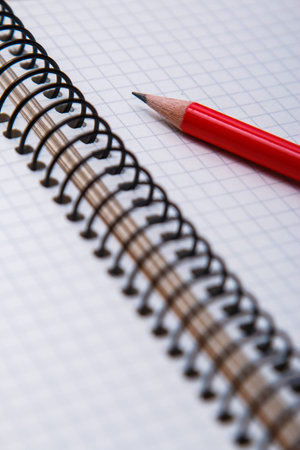 Empty notepad on wooden surface and red pencil