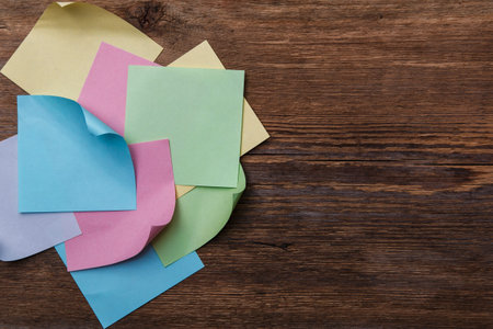 Multicolored paper stickers on wooden table